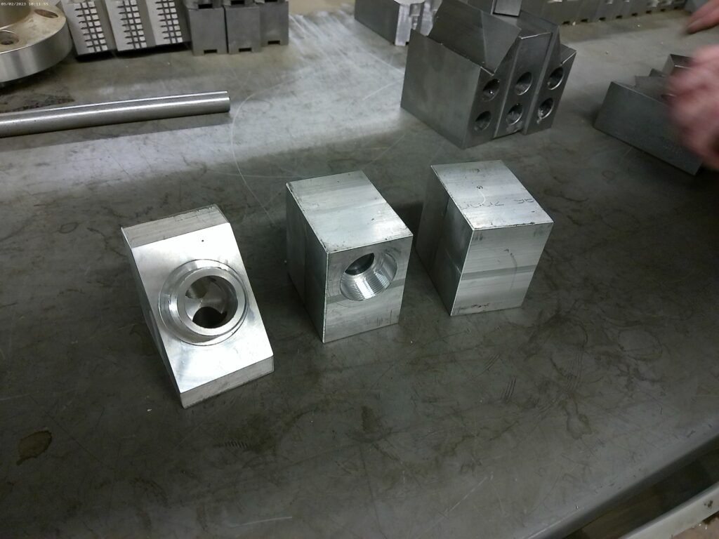 A metal block with two more metal blocks shaped into valves.